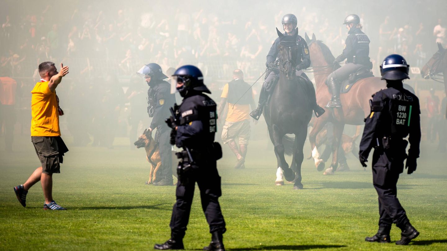 Polizisten auf dem Fußballplatz sorgen für Sicherheit während des Platzsturms nach dem gelungenen Aufstieg Dynamo Dresdens