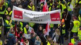 Demonstranten bei einem Warnstreik halten ein großes Banner mit der Aufschrift Bundesagentur für Arbeit und ver.di-Logos