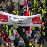 Demonstranten bei einem Warnstreik halten ein großes Banner mit der Aufschrift Bundesagentur für Arbeit und ver.di-Logos