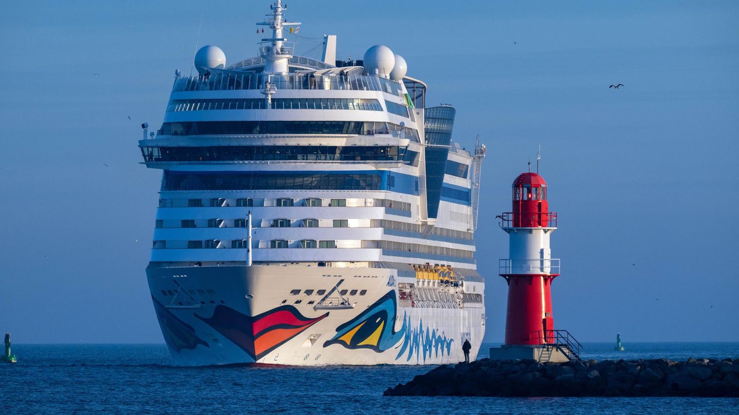 Platz 23: Aida Die "AIDAmar" neben einem Leuchtturm an der Ostsee vor Warnemünde