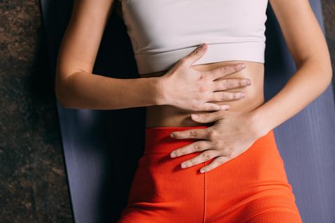 Schlankheitstrend: Frau fast sich auf den sehr flachen Bauch