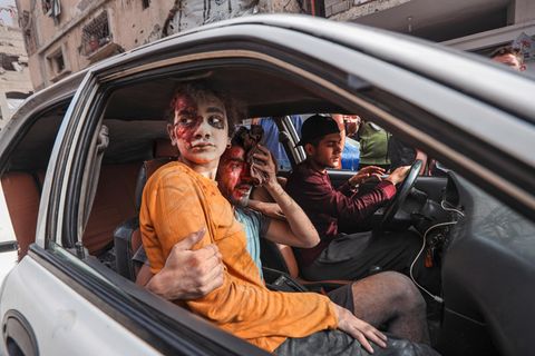ein Blutverschmiertes Mädchen sitzt mit verletzten Männern in einem Auto in Gaza