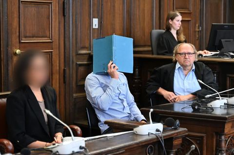 Der Angeklagte Anouar B. sitzt mit seinem Anwalt Tim Burkert (r.) und einer Dolmetscherin im Strafjustizgebäude in Hamburg. Die Anklage macht ihn dafür verantwortlich, dass seine Ex-Partnerin vom Balkon stürzte – und ihren Verletzungen erlag