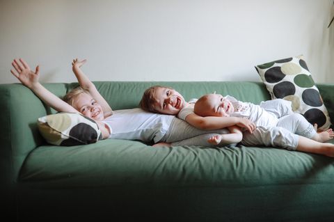 Geschwister liegen auf dem Sofa