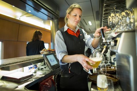 Eine Bahn-Mitarbeiterin zapft im Bordbistro ein Bier (Symbolbild)