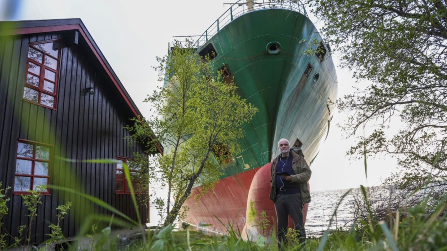 Johan Helberg vor seinem Haus und dem Containerschiff