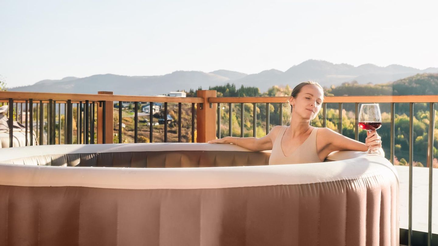 Mid-adult woman is relaxing in a hot tub in a sunny autumn day