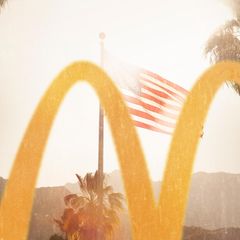 Im Vordergrund ein McDonalds Logo, im Hintergrund eine USA Flagge