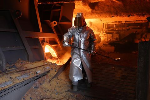 Forsa. Mann mit Schutzanzug in Stahlwerk