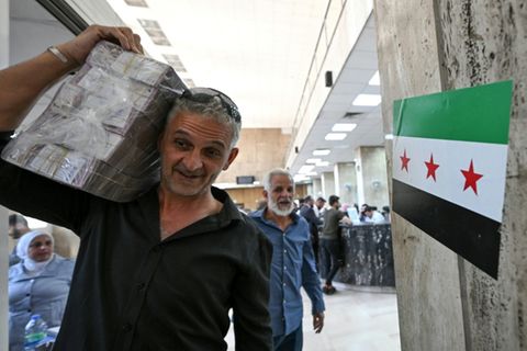 Mann mit syrischen Geldnoten in der Zentralbank in Damaskus, 21.5.