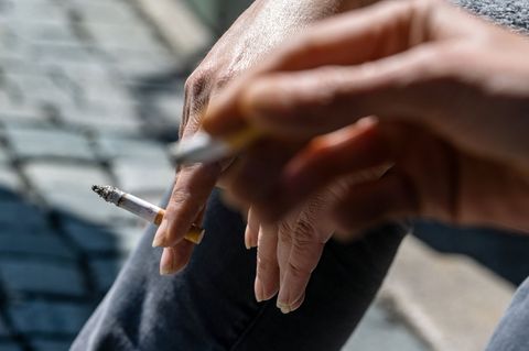 Rauchen: Eine Zigarette in einer Hand