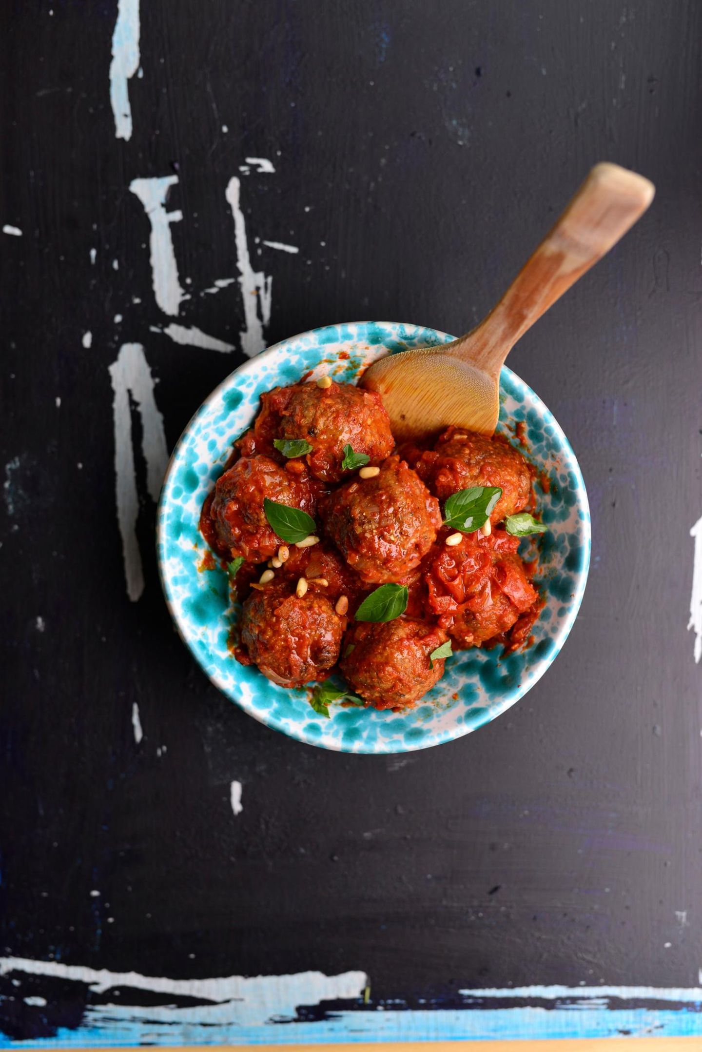    Polpette dolci  Süße Fleischklößchen mit Mandeln und Zimt  Für 4 Personen | Zubereitungszeit: 1 Stunde 30 Minuten  Kulinarische Geschichte: Diese süßen Fleischbällchen stammen aus dem Kloster San Carlo und waren das festlichste Essen für die Klosterkinder.     Für die Tomatensauce:2 EL Olivenöl1 große Zwiebel, klein geschnitten1 Knoblauchzehe, klein geschnitten1 EL Tomatenmark700 g Tomatenpassata1 Zimtstange  Für die Polpette:70 g blanchierte Mandeln20 g Zucker100 g Weißbrot, entrindet140 ml Milch480 g Rinderhackfleisch80 g Pecorino siciliano, gerieben30 g Rosinen20 g Pinienkerne1½ TL gemahlener Zimt2 Eier  Zubereitung:Für die Sauce Zwiebel und Knoblauch andünsten, Tomatenmark, Passata und Zimt zugeben, 10 Minuten köcheln.Mandeln mit Zucker grob pürieren. Brot in Milch einweichen.Alle Zutaten für die Polpette vermischen, 16 Klößchen formen.Polpette rundherum anbraten, in die Sauce geben, 20 Minuten köcheln lassen.Mit Oregano, Pinienkernen und Olivenöl garniert servieren.