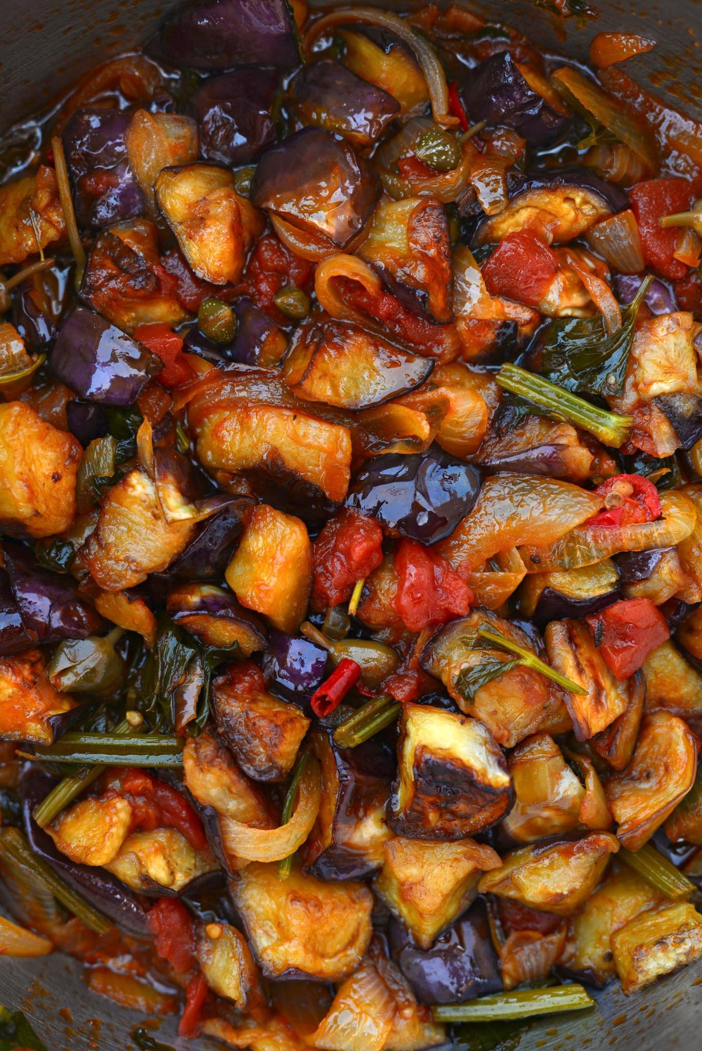 Kochbuch "Sizilien": Caponata con uova sode Gemüsetopf mit Eiern und St.-Bernardo-Sauce Für 4 Personen | Zubereitungszeit: 1 Stunde 20 Minuten Profi-Tipp: Die Caponata schmeckt am besten, wenn sie am Vortag zubereitet und lauwarm serviert wird – so können sich die Aromen voll entfalten. Zutaten:2 Auberginen, in große Stücke geschnitten1 große rote Paprikaschote, in Stücke geschnitten1 große Zwiebel, klein geschnitten2 EL kleine Kapern1 Handvoll grüne Oliven, entsteint1 frische rote Chilischote, gehackt1 Stange Staudensellerie, in Stücke geschnitten400 g reife Tomaten1 EL gehacktes Basilikum25-30 g Zucker125 ml Weißweinessig8 Eier, hart gekochtOlivenöl extra vergine Zubereitung:Auberginen und Paprika getrennt in Olivenöl halb gar anbraten.Zwiebel mit Kapern, Oliven, Chili und Sellerie anbraten.Tomaten häuten, klein schneiden, zu der Zwiebelmischung geben, einkochen lassen.Auberginen, Paprika und Basilikum zugeben, gar kochen.Zucker mit Essig vermischen, unterrühren, 5 Minuten köcheln.Lauwarm mit hart gekochten Eiern servieren. Caponata con uova sode Gemüsetopf mit Eiern und St.-Bernardo-Sauce Für 4 Personen | Zubereitungszeit: 1 Stunde 20 Minuten Profi-Tipp: Die Caponata schmeckt am besten, wenn sie am Vortag zubereitet und lauwarm serviert wird – so können sich die Aromen voll entfalten. Zutaten:2 Auberginen, in große Stücke geschnitten1 große rote Paprikaschote, in Stücke geschnitten1 große Zwiebel, klein geschnitten2 EL kleine Kapern1 Handvoll grüne Oliven, entsteint1 frische rote Chilischote, gehackt1 Stange Staudensellerie, in Stücke geschnitten400 g reife Tomaten1 EL gehacktes Basilikum25-30 g Zucker125 ml Weißweinessig8 Eier, hart gekochtOlivenöl extra vergine Zubereitung:Auberginen und Paprika getrennt in Olivenöl halb gar anbraten.Zwiebel mit Kapern, Oliven, Chili und Sellerie anbraten.Tomaten häuten, klein schneiden, zu der Zwiebelmischung geben, einkochen lassen.Auberginen, Paprika und Basilikum zugeben, gar kochen.Zucker mit Essig vermischen, unterrühren, 5 Minuten köcheln.Lauwarm mit hart gekochten Eiern servieren.