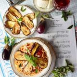Pasta alla Norma  Pasta mit Tomatensauce, Auberginenscheiben und Ricotta salata  Für 4 Personen | Zubereitungszeit: 50 Minuten  Das Geheimnis: Die Auberginen werden traditionell in viel Olivenöl gebraten, nicht gegrillt – nur so entsteht der authentische Geschmack!     Zutaten:700 g Auberginen1 kg reife Kirschtomaten2 rosa Knoblauchzehen, in Scheiben2 Handvoll Basilikum320 g Spaghetti80 g Ricotta salata, geriebenOlivenöl extra vergineGrobes MeersalzPeperoncinoflocken  Zubereitung:Auberginen längs in 5-7 mm dicke Scheiben schneiden, salzen, 30 Minuten entwässern lassen.Tomaten häuten und klein schneiden.Knoblauch in Olivenöl andünsten, Tomaten, Basilikum und Peperoncinoflocken zugeben, köcheln lassen.Auberginenscheiben portionsweise goldgelb braten. Vier Scheiben in Streifen zupfen.Spaghetti al dente kochen, mit Sauce und zerzupften Auberginen mischen.Mit ganzen Auberginenscheiben und Ricotta salata servieren.