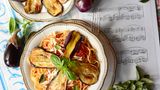 Pasta alla Norma  Pasta mit Tomatensauce, Auberginenscheiben und Ricotta salata  Für 4 Personen | Zubereitungszeit: 50 Minuten  Das Geheimnis: Die Auberginen werden traditionell in viel Olivenöl gebraten, nicht gegrillt – nur so entsteht der authentische Geschmack!     Zutaten:700 g Auberginen1 kg reife Kirschtomaten2 rosa Knoblauchzehen, in Scheiben2 Handvoll Basilikum320 g Spaghetti80 g Ricotta salata, geriebenOlivenöl extra vergineGrobes MeersalzPeperoncinoflocken  Zubereitung:Auberginen längs in 5-7 mm dicke Scheiben schneiden, salzen, 30 Minuten entwässern lassen.Tomaten häuten und klein schneiden.Knoblauch in Olivenöl andünsten, Tomaten, Basilikum und Peperoncinoflocken zugeben, köcheln lassen.Auberginenscheiben portionsweise goldgelb braten. Vier Scheiben in Streifen zupfen.Spaghetti al dente kochen, mit Sauce und zerzupften Auberginen mischen.Mit ganzen Auberginenscheiben und Ricotta salata servieren.