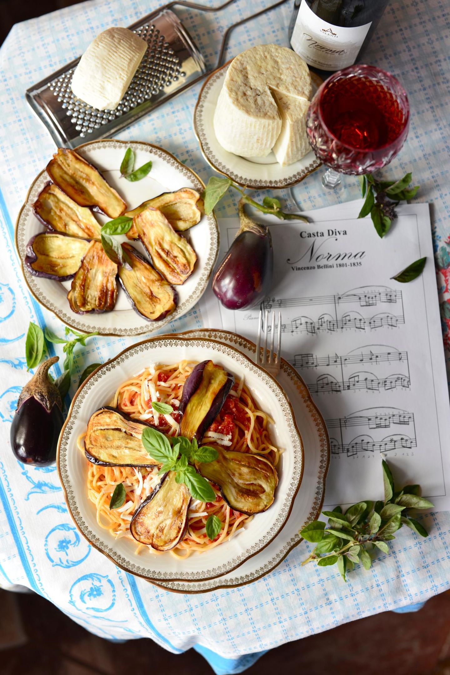 Kochbuch "Sizilien": Pasta alla Norma Pasta mit Tomatensauce, Auberginenscheiben und Ricotta salata Für 4 Personen | Zubereitungszeit: 50 Minuten Das Geheimnis: Die Auberginen werden traditionell in viel Olivenöl gebraten, nicht gegrillt – nur so entsteht der authentische Geschmack! Zutaten:700 g Auberginen1 kg reife Kirschtomaten2 rosa Knoblauchzehen, in Scheiben2 Handvoll Basilikum320 g Spaghetti80 g Ricotta salata, geriebenOlivenöl extra vergineGrobes MeersalzPeperoncinoflocken Zubereitung:Auberginen längs in 5-7 mm dicke Scheiben schneiden, salzen, 30 Minuten entwässern lassen.Tomaten häuten und klein schneiden.Knoblauch in Olivenöl andünsten, Tomaten, Basilikum und Peperoncinoflocken zugeben, köcheln lassen.Auberginenscheiben portionsweise goldgelb braten. Vier Scheiben in Streifen zupfen.Spaghetti al dente kochen, mit Sauce und zerzupften Auberginen mischen.Mit ganzen Auberginenscheiben und Ricotta salata servieren. Pasta alla Norma Pasta mit Tomatensauce, Auberginenscheiben und Ricotta salata Für 4 Personen | Zubereitungszeit: 50 Minuten Das Geheimnis: Die Auberginen werden traditionell in viel Olivenöl gebraten, nicht gegrillt – nur so entsteht der authentische Geschmack! Zutaten:700 g Auberginen1 kg reife Kirschtomaten2 rosa Knoblauchzehen, in Scheiben2 Handvoll Basilikum320 g Spaghetti80 g Ricotta salata, geriebenOlivenöl extra vergineGrobes MeersalzPeperoncinoflocken Zubereitung:Auberginen längs in 5-7 mm dicke Scheiben schneiden, salzen, 30 Minuten entwässern lassen.Tomaten häuten und klein schneiden.Knoblauch in Olivenöl andünsten, Tomaten, Basilikum und Peperoncinoflocken zugeben, köcheln lassen.Auberginenscheiben portionsweise goldgelb braten. Vier Scheiben in Streifen zupfen.Spaghetti al dente kochen, mit Sauce und zerzupften Auberginen mischen.Mit ganzen Auberginenscheiben und Ricotta salata servieren.