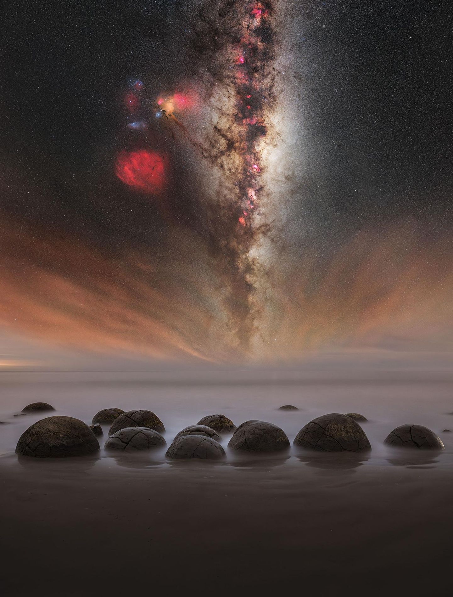 "Galaxie der Steinreihen" - Alvin Wu Die Moeraki Boulders an der Küste von Otago auf der Südinsel Neuseelands wirken wie von einem anderen Planeten: Die bis zu 2,20 Meter großen Felsen sind nahezu kugelförmig und ragen bei auflaufendem Wasser teilweise aus dem Meer. Alvin Wu fotografierte die Moeraki Boulders in der Nacht, flankiert vom leuchtenden Band der Milchstraße, das sich am Horizonz mit dem atmosphärischen Leuchten auf der Wasseroberfläche vermischt
