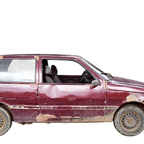Old, rusty red car with clear signs of wear
