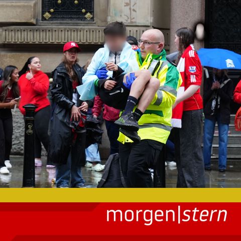 Ein Helfer trägt einen Jungen, nachdem ein Auto in eine Menschenmenge in Liverpool gefahren ist