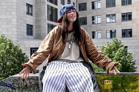Die US-amerikanische Sängerin Billie Eilish sitzt auf der "Billie Eilish-Wand" in Berlin