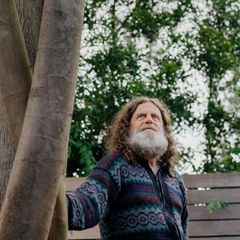 Neurowissenschaftler Robert M. Sapolsky steht leicht angelehnt an einem Baum