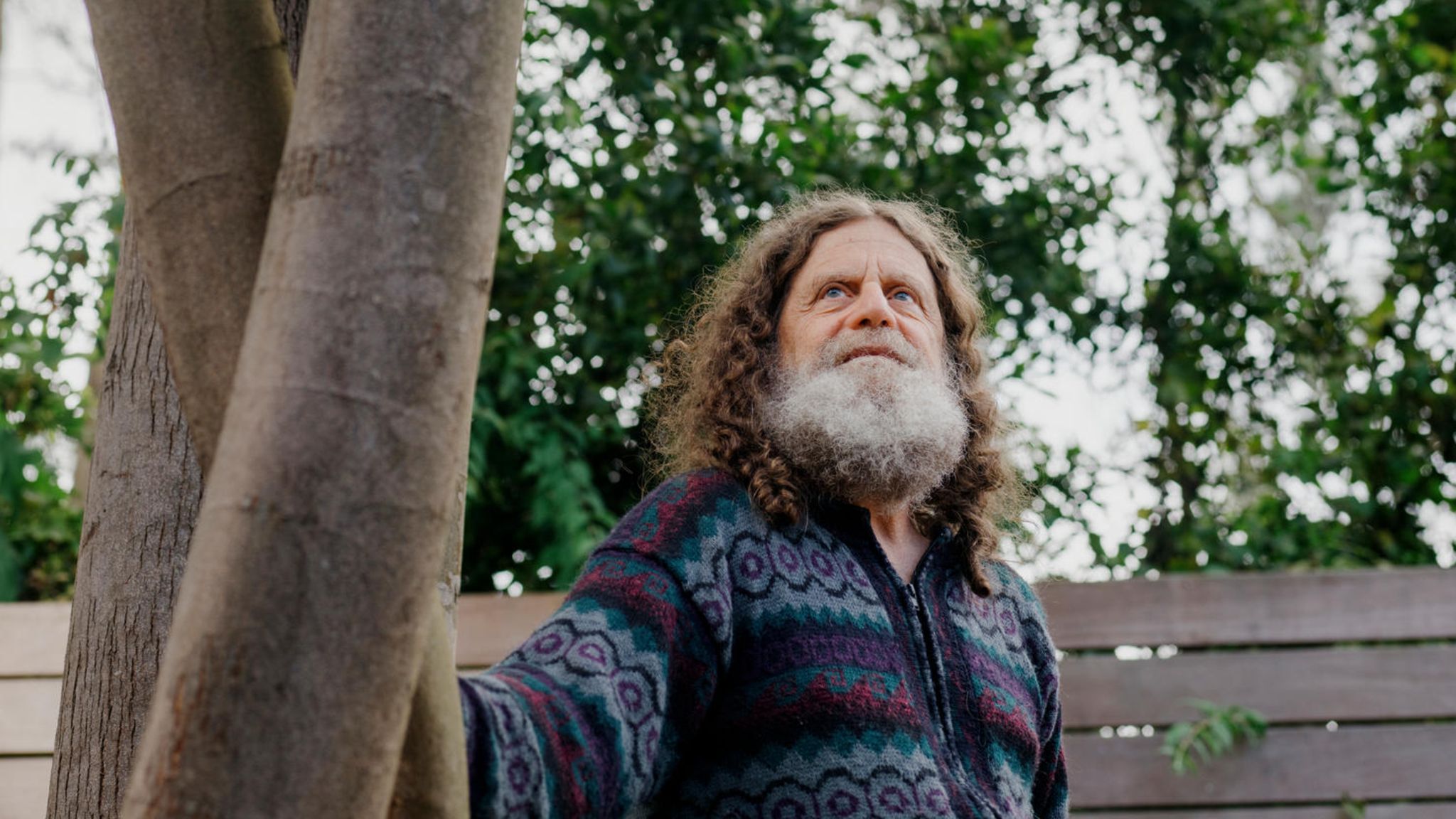 Neurowissenschaftler Robert M. Sapolsky steht leicht angelehnt an einem Baum