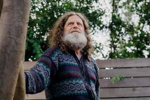 Neurowissenschaftler Robert M. Sapolsky steht leicht angelehnt an einem Baum