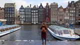 Frau macht ein Foto von den Häusern in Amsterdam