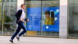 Ein Mann läuft an einem Schaufenster der Zeitarbeitsfirma Randstad vorbei