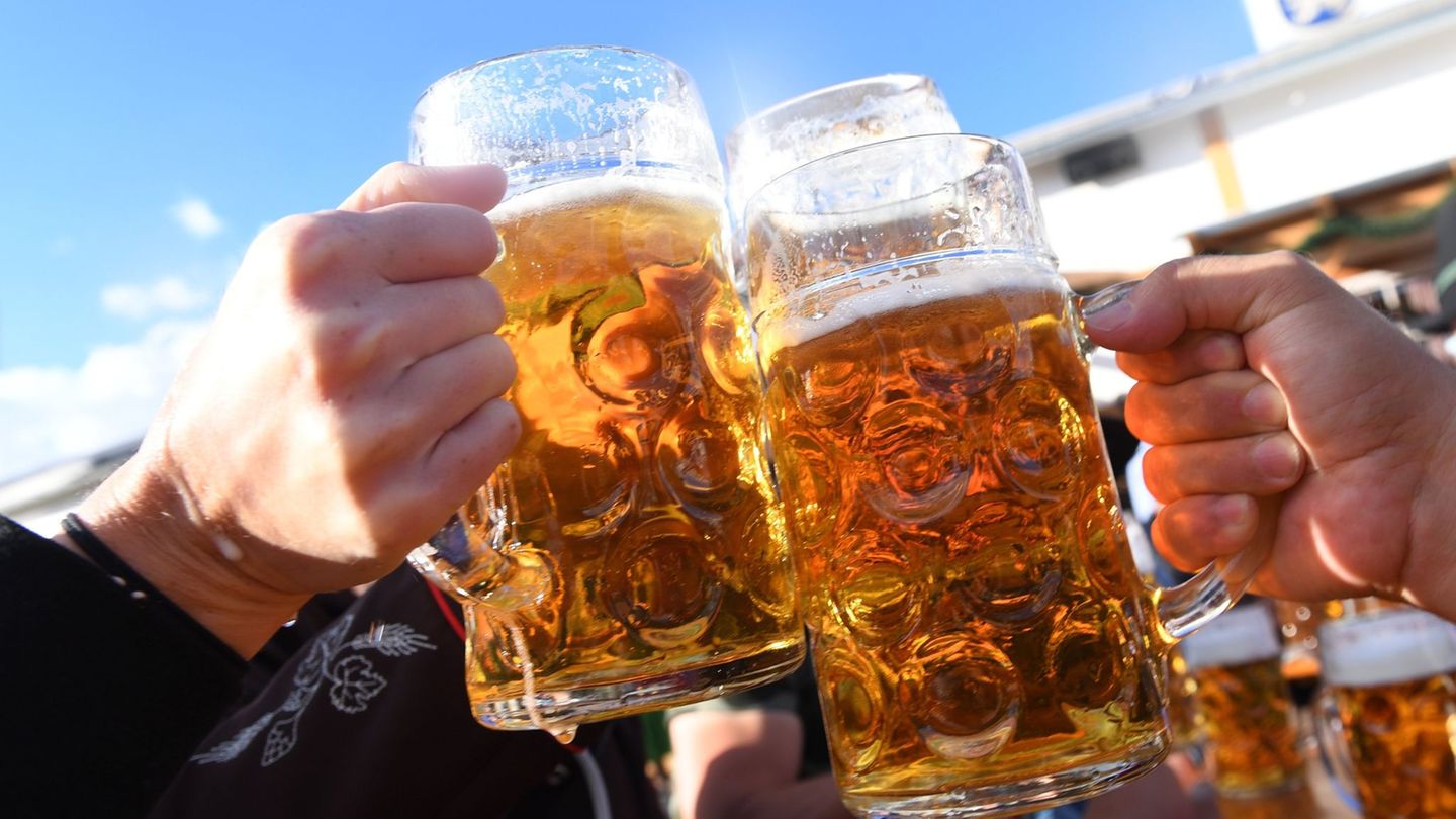 Oktoberfest: Menschen stoßen mit Maß Bier an