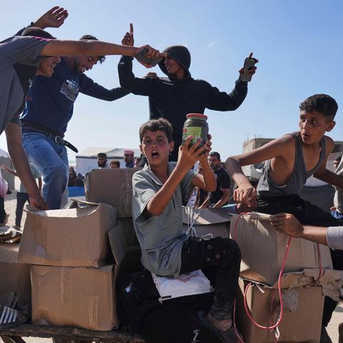 Palästinenser im Gazastreifen tragen Kisten mit Lebensmitteln und humanitären Hilfspaketen