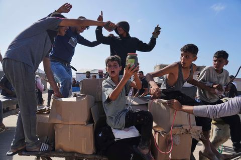 Palästinenser im Gazastreifen tragen Kisten mit Lebensmitteln und humanitären Hilfspaketen