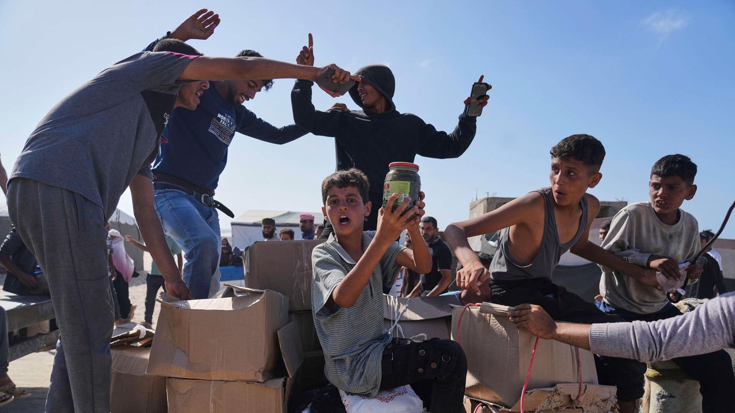 Palästinenser im Gazastreifen tragen Kisten mit Lebensmitteln und humanitären Hilfspaketen