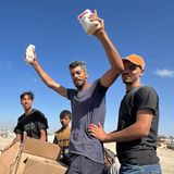 Wie Sport-Trophäen stemmt dieser Mann zwei Päckchen mit Lebensmitteln in den Himmel