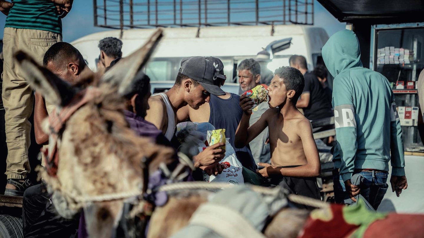 Nach Monaten der Blockade: Vor Hunger begnügen sich manche Wartende mit trockenen Nudeln direkt aus der Packung – denn auch Trinkwasser ist knapp. Doch laut israelischen Medienberichten und Augenzeugen ist es auch zu chaotischen Szenen gekommen. Die israelische Armee teilte mit, Soldaten hätten außerhalb des Zentrums Warnschüsse abgegeben Vor Hunger begnügen sich manche Wartende mit trockenen Nudeln direkt aus der Packung – denn auch Trinkwasser ist knapp. Doch laut israelischen Medienberichten und Augenzeugen ist es auch zu chaotischen Szenen gekommen. Die israelische Armee teilte mit, Soldaten hätten außerhalb des Zentrums Warnschüsse abgegeben