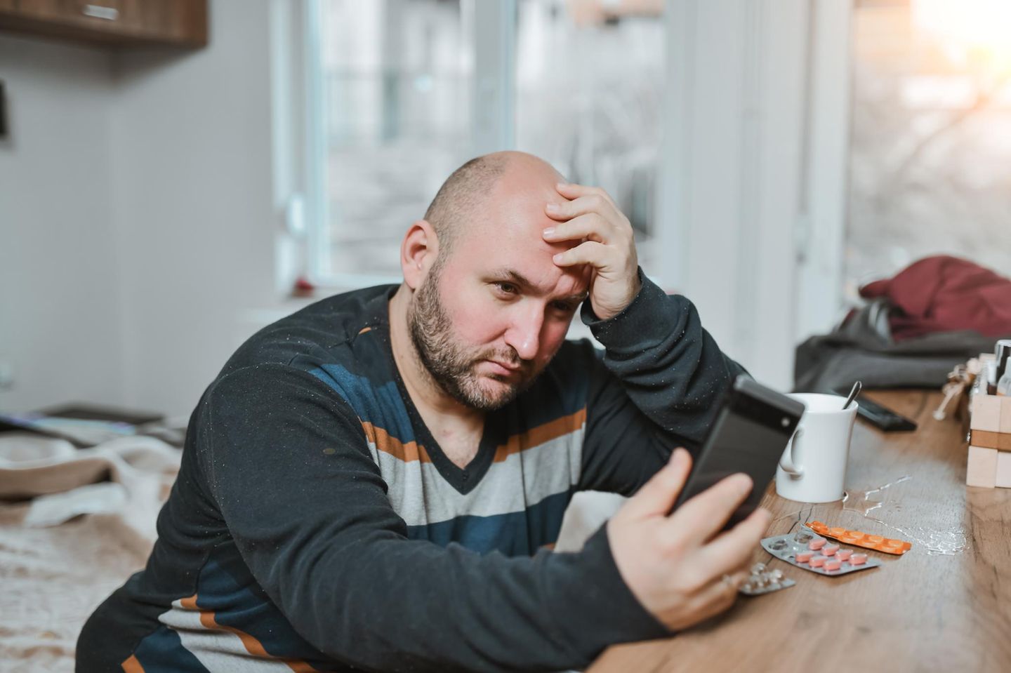 Ein Mann mittleren Alters schaut genervt auf sein Handy