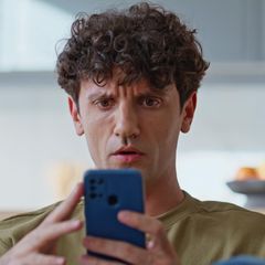 Ein Mann mittleren Alters schaut genervt auf sein Handy
