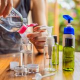 Eine Frau füllt Seifenflaschen mit einem Nachfüllbeutel auf