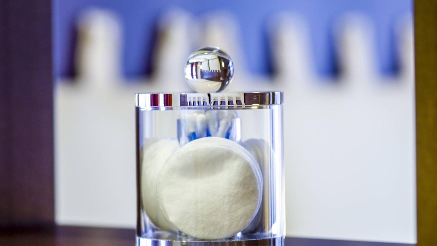Eine Glasdose mit Abschminkpads aus Watte Eine Glasdose mit Abschminkpads aus Watte