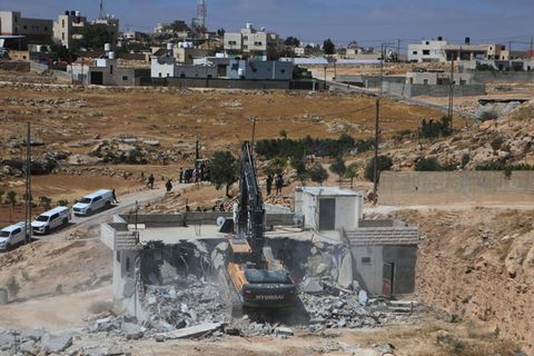 Ein israelischer Bagger reißt ein palästinensisches Haus in der Stadt Yatta, südlich der Westjordanland-Stadt Hebron, ab