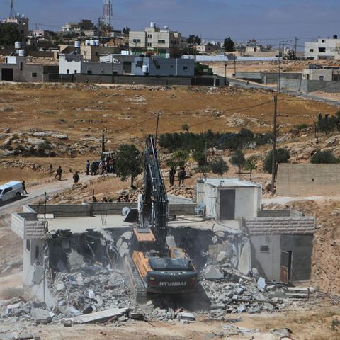 Ein israelischer Bagger reißt ein palästinensisches Haus in der Stadt Yatta, südlich der Westjordanland-Stadt Hebron, ab