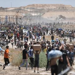 Vertriebene Palästinenser im Gazastreifen tragen Pakete mit Nahrungsmitteln