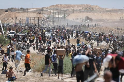 Vertriebene Palästinenser im Gazastreifen tragen Pakete mit Nahrungsmitteln