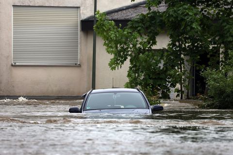 Ein Auto steht im Hochwasser der Mindel in einem bayrischen Wohngebiet (Symbolbild)