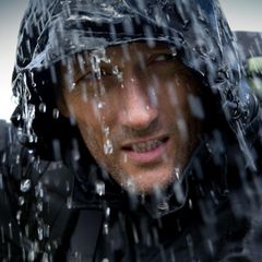 Ein Mann steht mit seiner Regenjacke von Columbia im Regen