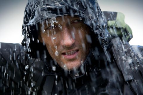 Ein Mann steht mit seiner Regenjacke von Columbia im Regen