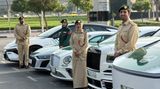 Polizisten aus Dubai posieren vor ihren Autos