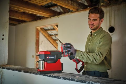 Akku Kaffeemaschine: Handwerker mit mobiler Kaffeemaschine in einem Haus
