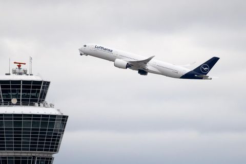 Ein Flugzeug der Lufthansa startet am Flughafen München und fliegt am Tower vorbei