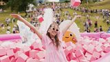 Frau steht lachend in einem pinkfarbenen Spielebecken